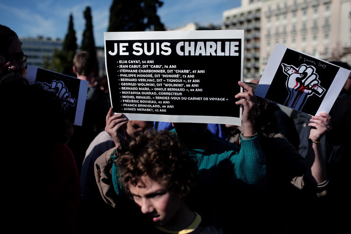 A woman holds a sign reading "je suis Charlie" and the list of the journalists who were killed in the attack on the offices of Charlie Hebdo, in front of the Greek Parliament in Athens on January 11, 2015 (AFP Photo / Angelos Tzortzinis)