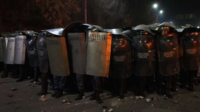 Armenian police officers hold up their shields as they stand guard during clashes with protesters at a demonstration near the Russian Consulate General in Gyumri, north-western Armenia, on January 15, 2015.(AFP Photo / Karen Minasyan)