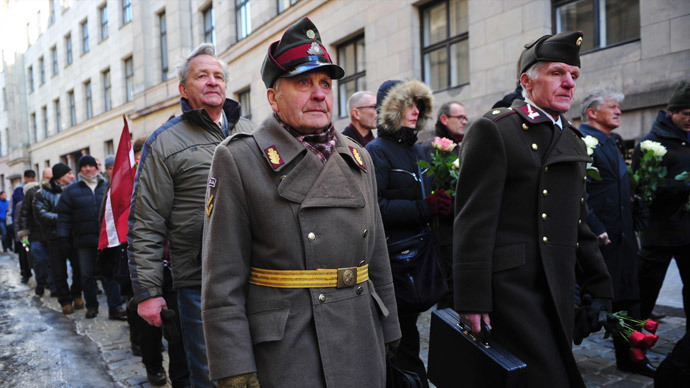 Two man dressed in pre-WWII Latvian military uniforms walk along with veterans of the Latvian Legion, a force that was commanded by the German Nazi Waffen SS, and their sympathizers to the Monument of Freedom in Riga, Latvia.(AFP Photo / Ilmars Znotins)