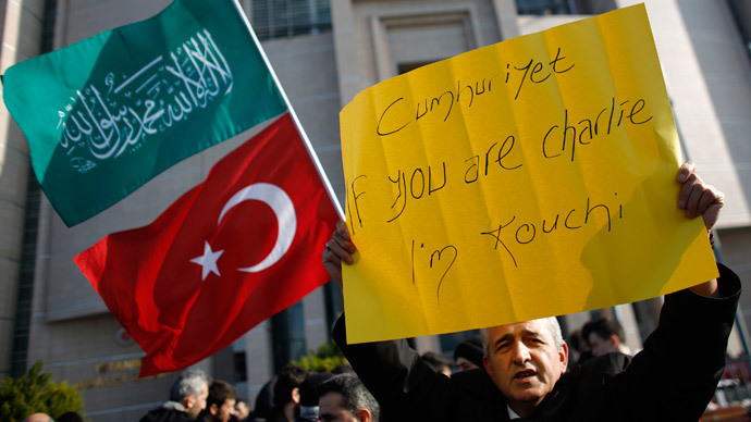 A demonstrator holds a banner as others wave Turkish and Islamic flags during a protest against Cumhuriyet, a staunchly secular opposition newspaper, in Istanbul January 15, 2015.(Ruters / Murad Sezer)