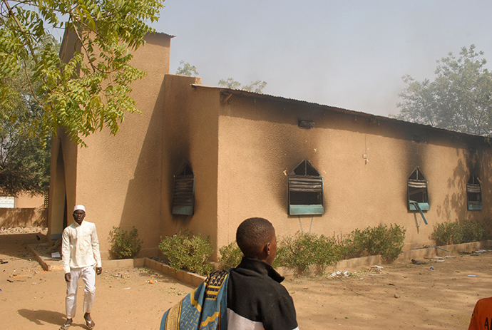 Residents watch a ransacked church that burned after thousands of protesters gathered following Friday prayers to vent anger at the depiction of the prophet in the publication of a cartoon of the Prophet Mohammed in the latest edition of the French satirical weekly, Charlie Hebdo, on January 16, 2015 in Zinder (AFP Photo / STR)