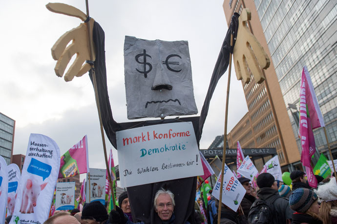 A protestor holds up a figure with a sign reading "market-compliant democracy- we rule elections" (marktkonforme Demokratie- Die Wahlen bestimmen wir) during a demonstration against the TTIP (Transatlantic Trade and Investment Pact) in Berlin, on January 17, 2015. (AFP/DPA)