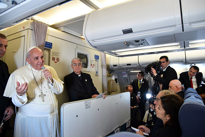 Pope Francis addresses journalist sitting onboard a plane during his trip back to Rome, on January 19, 2015 from the Philippines. (AFP Photo/Giuseppe Cacace)