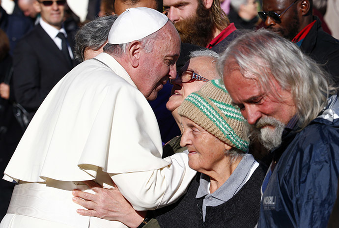 Pope Francis, who's 78th birthday is today, blesses a homeless person at the end of his general audience at the Vatican, December 17, 2014. (Reuters/Tony Gentile)