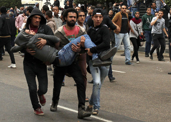 Anti-government protesters help an injured protester when pro-government protesters threw stones during a protest in front of the press syndicate in Cairo January 25, 2015. (Reuters/Asmaa Waguih)