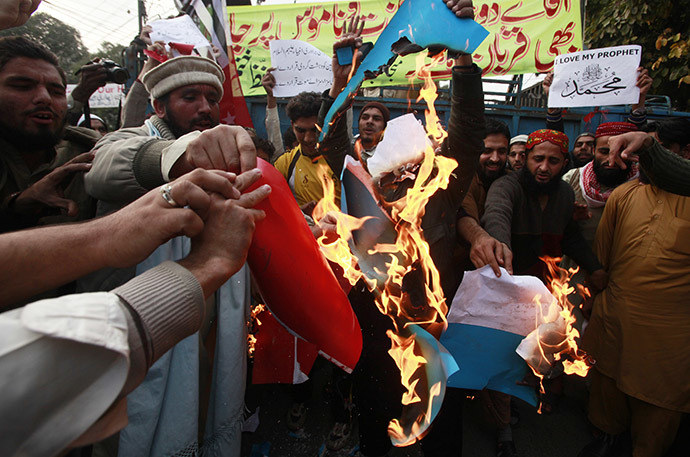 Supporters of religious groups burn a replica of French flag during a protest against satirical French weekly newspaper Charlie Hebdo, in Lahore January 23, 2015. (Reuters/Mohsin Raza)