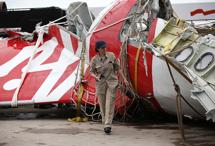 An Airbus investigator walks near part of the tail of the AirAsia QZ8501 passenger plane in Kumai Port, near Pangkalan Bun, Central Kalimantan January 12, 2015. (Reuters/Darren Whiteside)