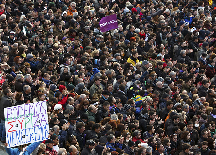 A man holds up a banner as people gather during a rally called by Spain's anti-austerity party Podemos, at Madrid's Puerta del Sol landmark January 31, 2015. (Reuters/Sergio Perez)