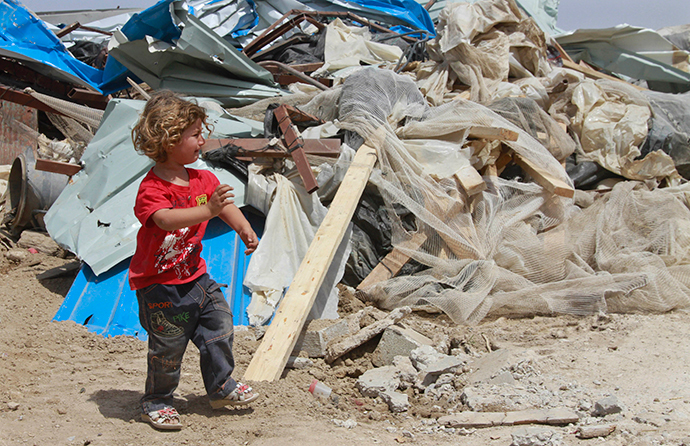 A Palestinian girl walks past her family's house after it was demolished by Israeli bulldozers in Om Ajaj village, north of the West Bank city of Jericho (Reuters / Abed Omar Qusini)