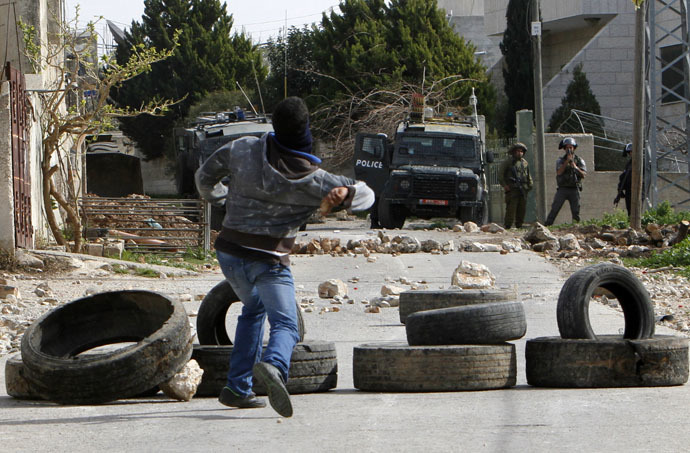 A Palestinian protester throws stones at Israeli border policemen during clashes following a protest against the near-by Jewish settlement of Qadomem, in the West Bank village of Kofr Qadom near Nablus February 6, 2015. (Reuters)
