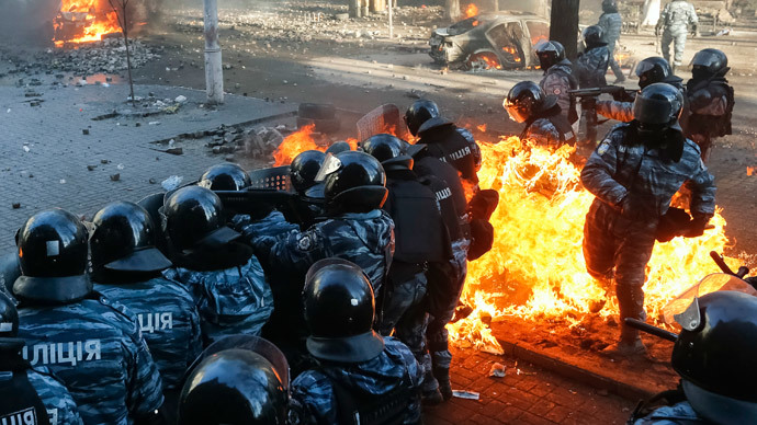 Riot policemen stand guard as they are hit by fire caused by molotov cocktails hurled by anti-government protesters during clashes in Kiev February 18, 2014.(Reuters / Stringer)