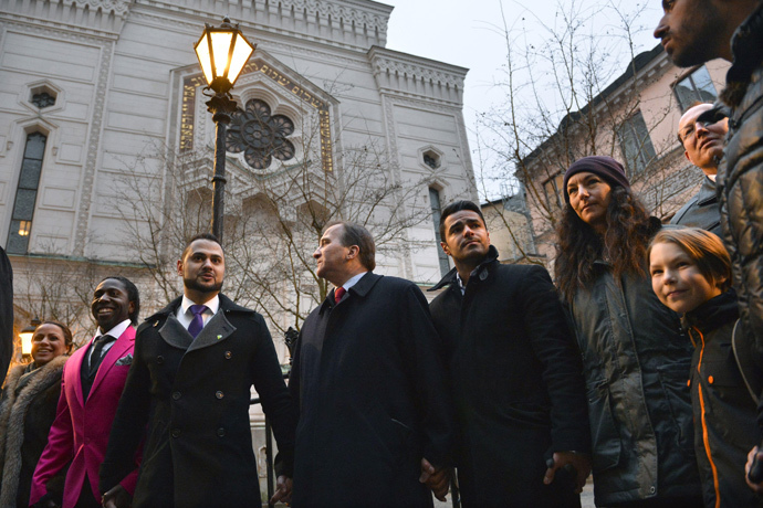 Swedish Prime Minister Stefan Lofven (C) holds hands with the representatives of various minority group organisations Emir Selimi (C, left) Mohammed Mouaid (C, right) and Petra Kahn Nord with her son Gabriel (R), as people gather to form a "ring of peace" around The Great Synagogue of Stockholm at Raoul Wallenberg, in central Stockholm February 27, 2015. (Reuters / Henrik Montgomery / TT News Agency)