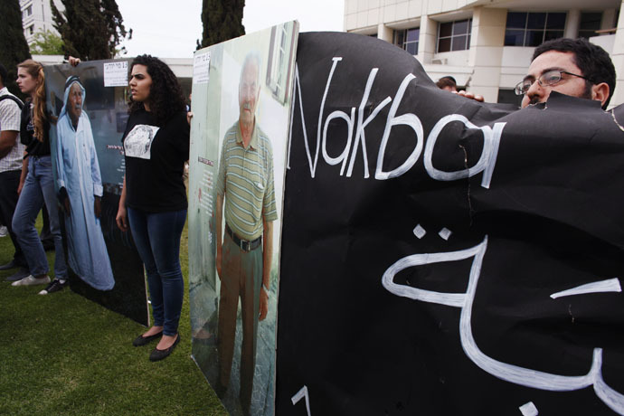 Pro-Palestinian demonstrators hold boards during a rally marking Nakba Day, outside Tel Aviv University (Reuters/Nir Elias)