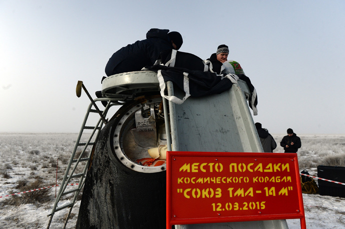 Russia's space agency ground personnel check the Soyuz capsule shortly after it landed in a remote area outside the town of Zhezkazgan in central Kazakhstan, March 12, 2015. (Reuters / Vasily Maximov / Pool)