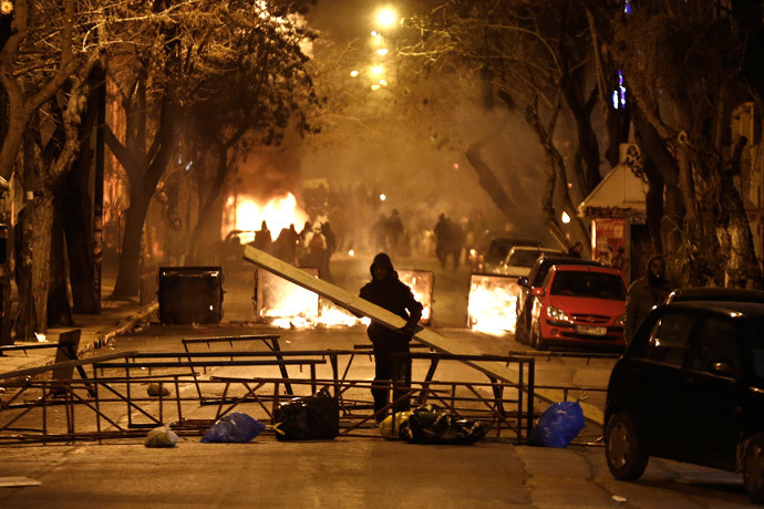 A masked youth places a wooden beam at a barricade during clashes with riot police in Athens March 17, 2015. (Reuters / Alkis Konstantinidis)