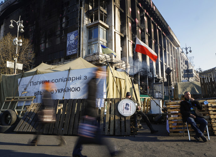 Pedestrians walk past the 'Euromaidan' protest camp at the Independence Square in Kiev, March 31, 2014. (Reuters / Shamil Zhumatov)