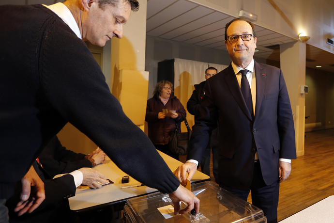 French President Francois Hollande (R) casts his ballot in the first round of French local elections, as he votes in Tulle, central France, March 22, 2015. (Reuters / Regis Duvignau)