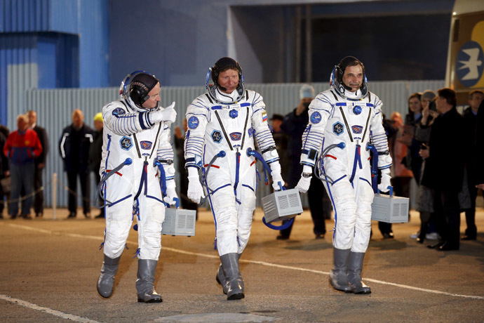 International Space Station (ISS) crew of (L-R) Scott Kelly of the U.S. and Mikhail Kornienko and Gennady Padalka of Russia walk after donning space suits at the Baikonur cosmodrome March 27, 2015 (Reuters/Maxim Zmeyev)