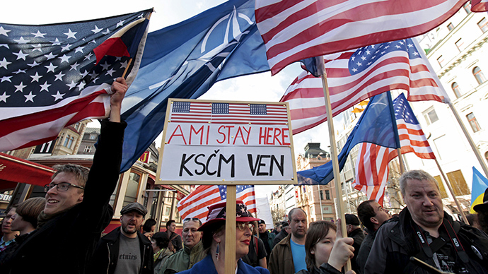 Supporters of the U.S. Army's "Dragoon Ride" military exercise wave U.S. flags as they oppose a demonstration against the exercise in Prague March 28, 2015 (Reuters / David W Cerny)