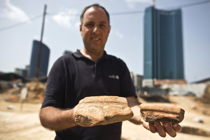 Diego Barkan, director of the excavation for the Israel Antiquities Authority (IAA), shows fragments of ancient basins unearthed at an archaeological dig in a future construction site in Tel Aviv March 29, 2015. (Reuters / Nir Elias)