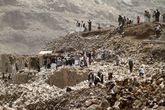 People stand on the rubble of houses destroyed by an air strike in Okash village near Sanaa April 4, 2015. (Reuters / Mohamed al-Sayaghi)