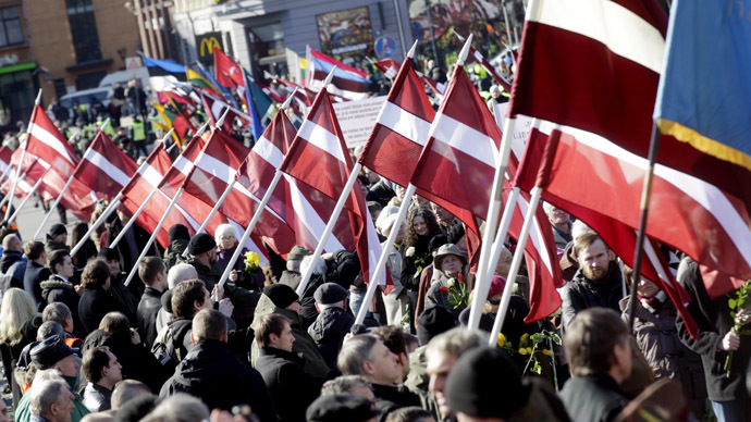 People hold flags as they participate in the annual procession commemorating the Latvian Waffen-SS (Schutzstaffel) unit, also known as the Legionnaires, in Riga March 16, 2015. (Reuters/Ints Kalnins)