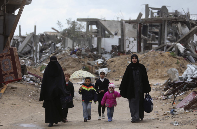 Palestinians walk near the ruins of houses that witnesses said were destroyed or damaged by Israeli shelling during a 50-day war last summer, on a winter day east of Gaza City February 20, 2015. (Reuters/Ibraheem Abu Mustafa)