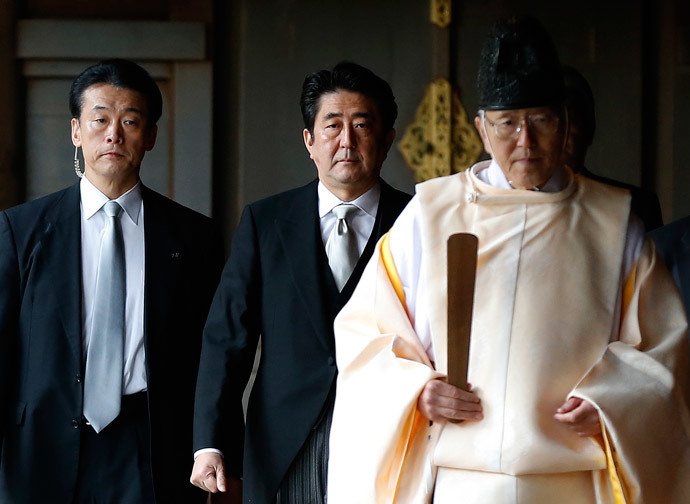 Japan's Prime Minister Shinzo Abe (C) is led by a Shinto priest as he visits Yasukuni shrine in Tokyo December 26, 2013. (Reuters / Toru Hanai)