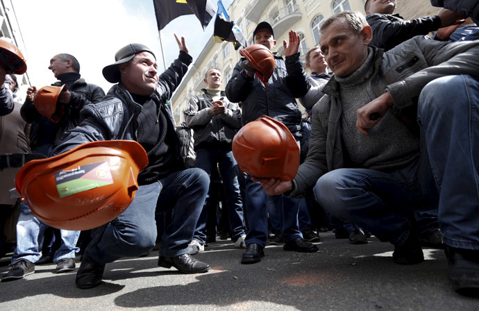 Miners bang their helmets on the ground during a rally to demand the payment of their salaries from the government in central Kiev April 22, 2015. (Reuters / Valentyn Ogirenko)