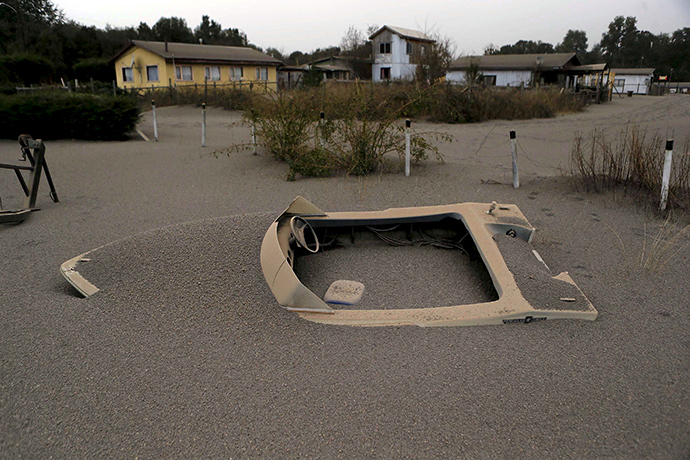 A boat is seen in a house backyard at Ensenada town which is covered with ash from Calbuco volcano near Puerto Varas city, April 23, 2015 (Reuters / Ivan Alvarado)