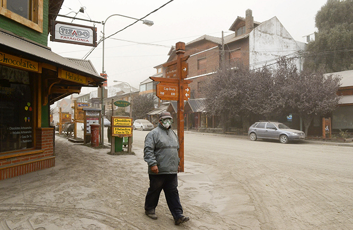 A man wearing a surgical mask to protect himself against ash from Calbuco volcano, walks by the Patagonian Argentine area of San Marin de Los Andes April 23, 2015 (Reuters / Patricio Rodriguez)
