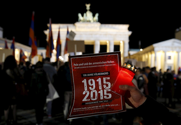 A participant holds a candle and a sign during a memorial march by armenians in front of the Brandenburg Gate after an Ecumenical service marking the 100th anniversary of the mass killings of 1.5 million Armenians by Ottoman Turkish forces, at the cathedral in Berlin April 23, 2015. (Reuters/Fabrizio Bensch)