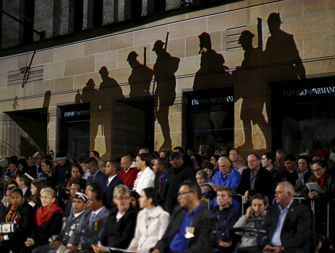 Silhouettes of ANZAC (Australian and New Zealand Army Corps) troops are projected onto the wall of a building above the crowd during the dawn of ANZAC Day 100th anniversary commemoration at Sydney's Cenotaph in Australia, April 25, 2015. (Reuters/Jason Reed)