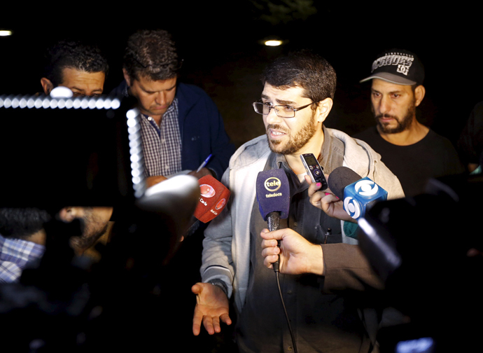 Former Guantanamo detainees Omar Mahmoud Faraj (2nd R) and Abdul din Muhammed Tawes (R) talk to the media in front of the U.S. embassy in Montevideo, April 24, 2015. (Reuters / Andres Stapff)