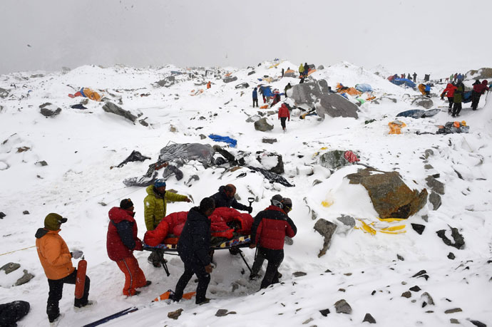 In this photograph taken on April 25, 2015, rescuers use a makeshift stretcher to carry an injured person after an avalanche triggered by an earthquake flattened parts of Everest Base Camp. (AFP Photo/Roberto Schmidt)