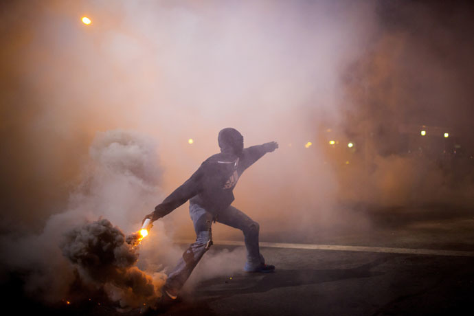 A protester throws a gas canister back at police during clashes at North Ave and Pennsylvania Ave in Baltimore, Maryland April 28, 2015. (Reuters/Eric Thayer)