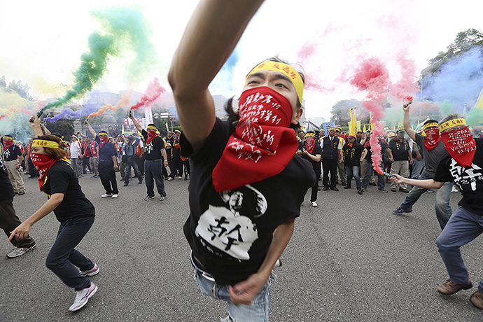 People throw smoke grenades during the annual Labour Day protest in front of Presidential Office in Taipei, Taiwan, May 1, 2015 (Reuters / Patrick Lin)