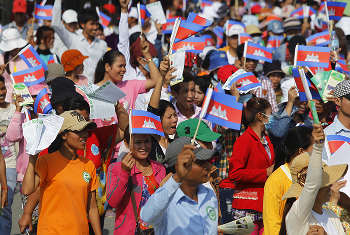 Garment workers shout and wave Cambodian national flags as they take part in a protest calling on the government to raise wages during a march to mark Labour Day in Phnom Penh May 1, 2015 (Reuters / Samrang Pring)