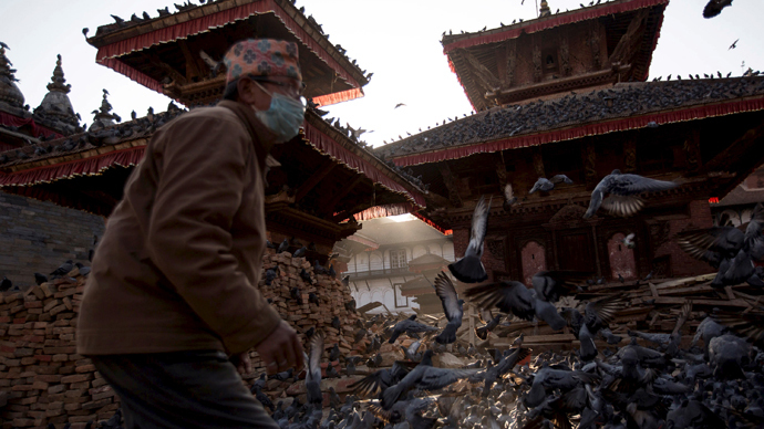 A man arrives to feed pigeons at a temple damaged after an earthquake in Kathmandu, Nepal, May 3, 2015. (Reuters / Danish Siddiqui)