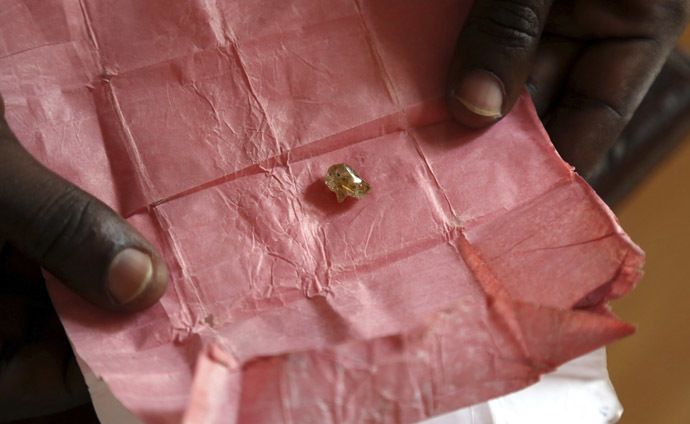 A man displays a rough diamond. (Reuters/Emmanuel Braun)