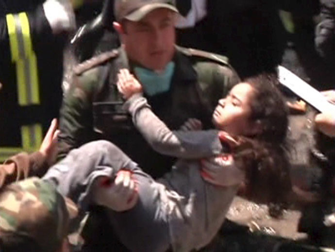 An emergency worker carries a girl evacuated from a multi-storey residential building on fire to an ambulance in Baku, Azerbaijan, in this still image taken from video shot on May 19, 2015. (Reuters/Reuters TV)