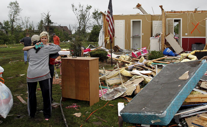 Amy Parrish (2nd L) hugs a woman as she gathers personal items from her home after a tornado swept through the area the previous night in Van, Texas May 11, 2015. (Reuters/Mike Stone)