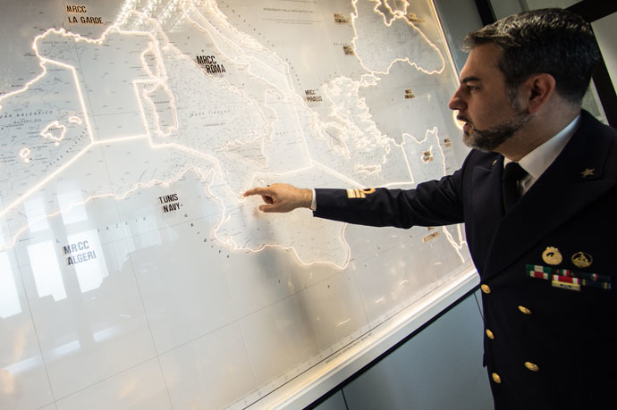 Italian officer Gianluca D'Agostino of the Italian Coast Guard, looks at a map of the Mediterranean Sea, in the control center at the headquarter of Italian Coast Guard, on May 28 2015, in Rome. (AFP Photo/Andreas Solaro)