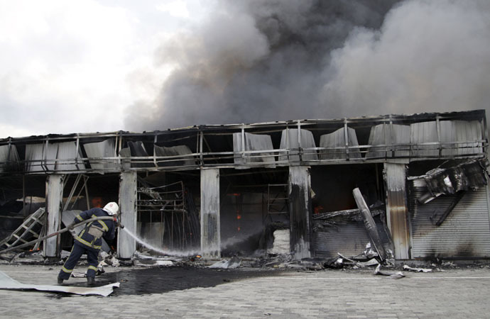 A firefighter works to extinguish a fire at a local market, which was recently damaged by shelling, in Donetsk, Ukraine, June 3, 2015. (Reuters/Alexander Ermochenko)