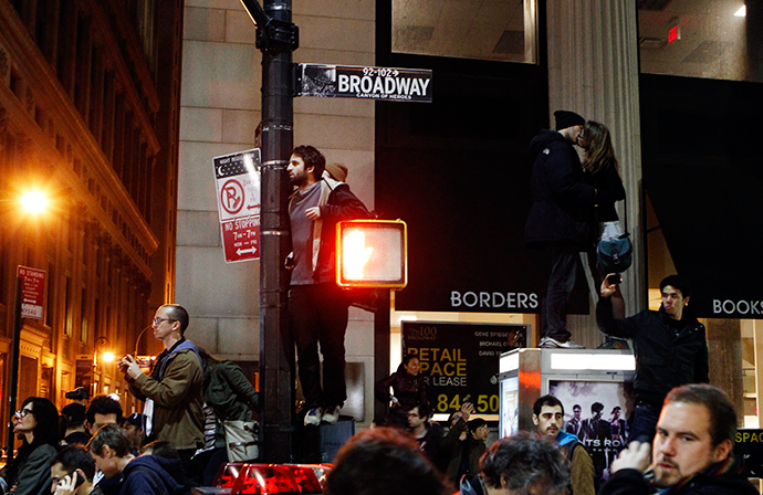 A couple kiss as they stand on top of a telephone booth as they are surrounded by demonstrators affiliated with the Occupy Wall St. movement near Zuccotti Park in New York November 15, 2011 (Reuters / Lucas Jackson)