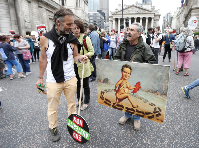 A demonstrator looks at an artist holding a painting showing Britain's Chancellor George Osborne, during an anti-austerity protest in London, Britain June 20, 2015. (Reuters / Suzanne Plunkett)