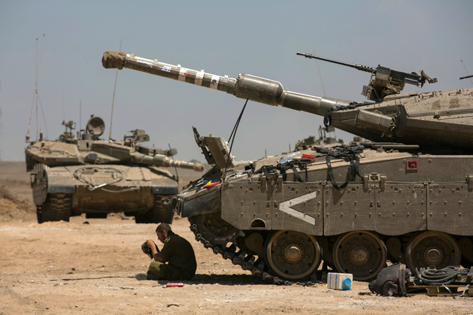 An Israeli soldier sits next to tanks at a staging area near the border with the Gaza Strip August 21, 2014. (Reuters / Baz Ratner)