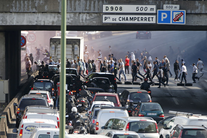 French taxi drivers, who are on strike, block the traffic on the Paris ring road during a national protest against car-sharing service Uber, in Paris, France, June 25, 2015. (Reuters / Charles Platiau)