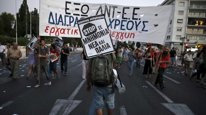 A protester carries a placard that reads "Stop to new and old bailouts" during an anti-bailout demonstration in Athens, Greece June 25, 2015. (Reuters / Alkis Konstantinidis)