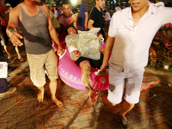 People carry an injured victim from an accidental explosion during a music concert at the Formosa Water Park in New Taipei City, Taiwan, June 27, 2015 (Reuters / Chen Bo)